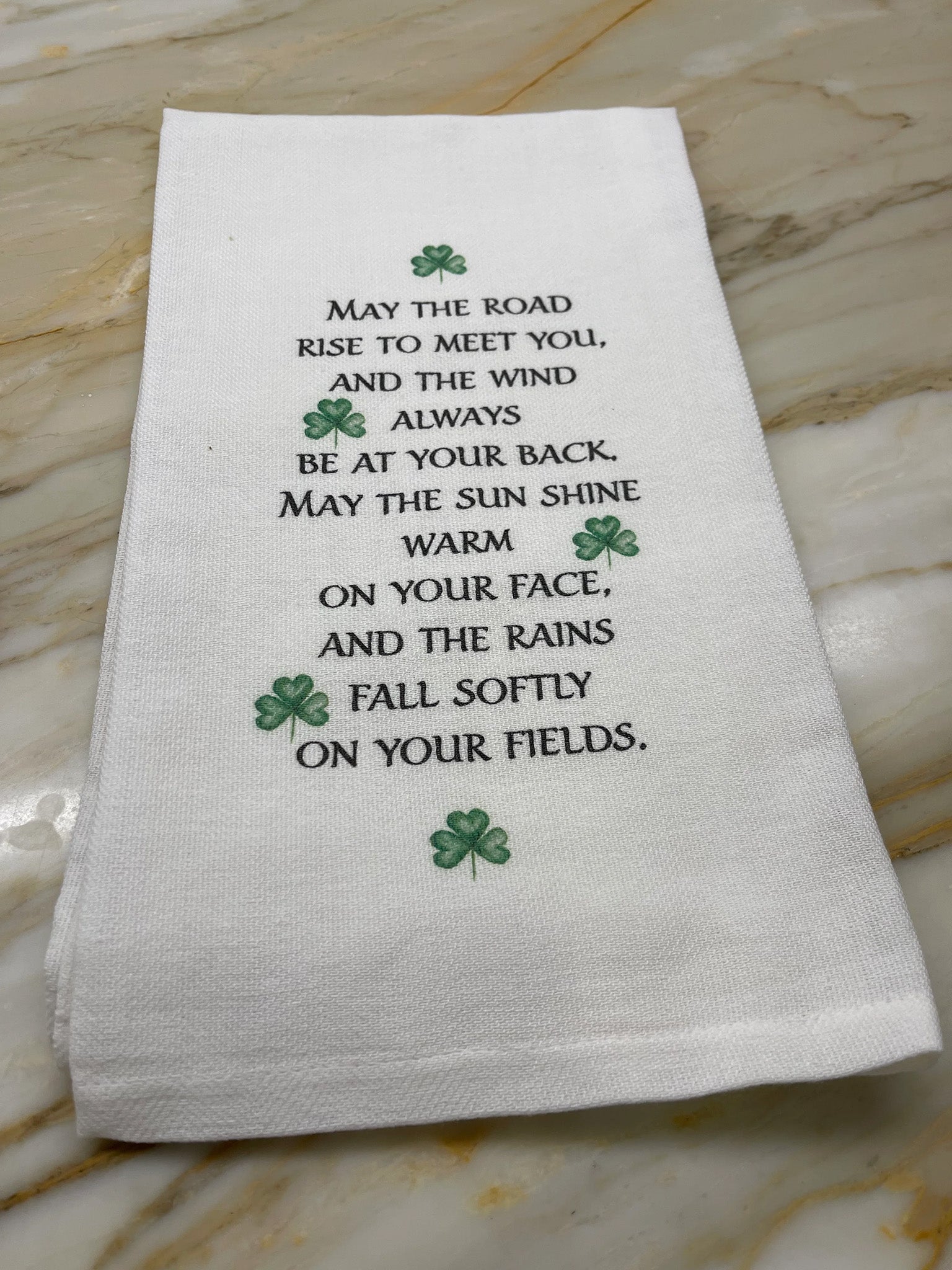 May the Road Rise to Meet You and the Wind Always be at your back - words on a dishtowel with shamrocks.